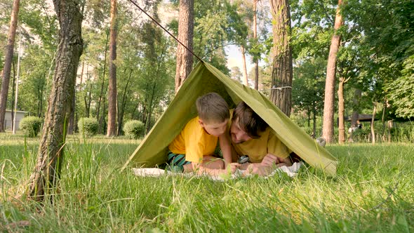 Two Travelers Having Fun in Tent. Traveling Close To Home. Father with Son Lying in Camp Tent