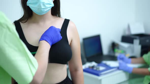 Unrecognizable Female Patient Standing Indoors As Male Doctor Using Stethoscope for Auscultation