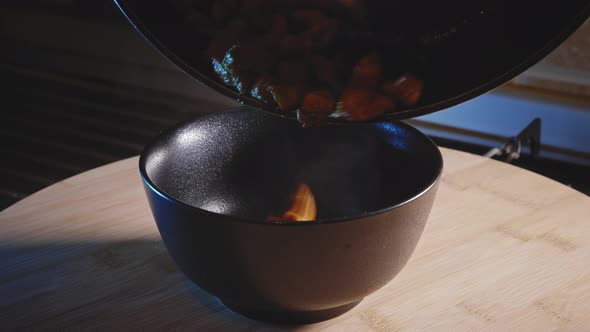 Serving Steaming Hot Fried Chicken Breast From Pan To Bowl - Close-up View