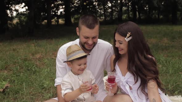 Cheerful Caucasian Mum, Dad and Their Child Have Fun Together and Smiles in the Garden