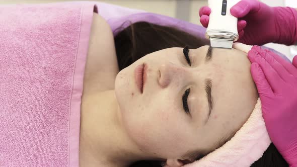 Ultrasonic scrabbing. Young woman receiving ultrasound cavitation facial peeling cleansing.