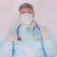 Doctor in a white coat personal protective equipment and protective mask with two thumbs up. Success - VideoHive Item for Sale