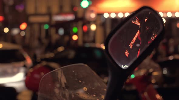 Parisian street with traffic and Moulin Rouge reflection in motorbike mirror