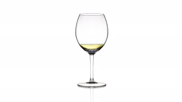 Empty Glass Filling with Sparkling Wine on White Background
