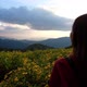 Slow motion of a woman looking at Mexican sunflower in the park and a beautiful mountain views - VideoHive Item for Sale