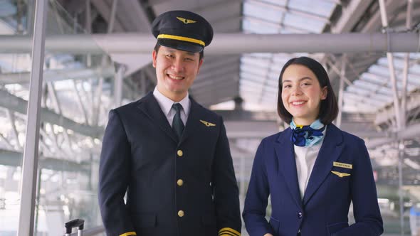 Airliner pilot and air hostess removing face mask in airport terminal after the COVID pandemic.