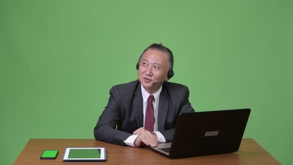 Mature Japanese Businessman Working As Call Center Representative