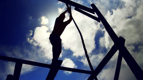 Military soldier climbing rope during obstacle course 4k