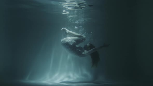 Underwater Gymnastics of a Beautiful Girl in a White Dress