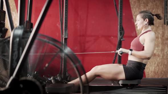 Female athlete rowing in the gym