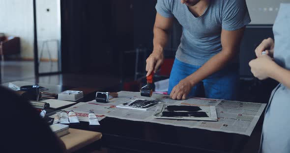 Male Artist in Linocuts Paints a Plastic Tablet with Acrylic Paint