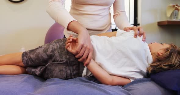 Female physiotherapist giving hand massage to boy patient 4k
