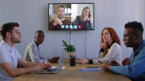 Creative business colleagues in video conference in meeting room in modern office