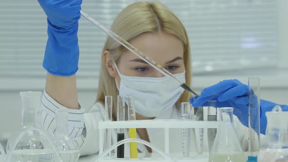 Chemical Research Scientist Working In The Lab. Scientist In Protective Workwear Pour Liquid In Tube