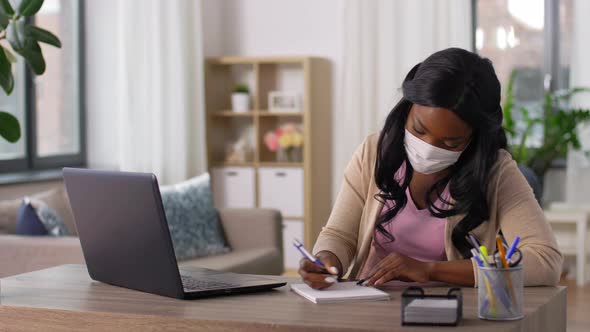 Woman in Mask with Laptop Working at Home Office
