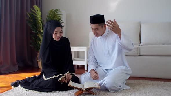 Handsome Muslim man teaching young woman read Quran 