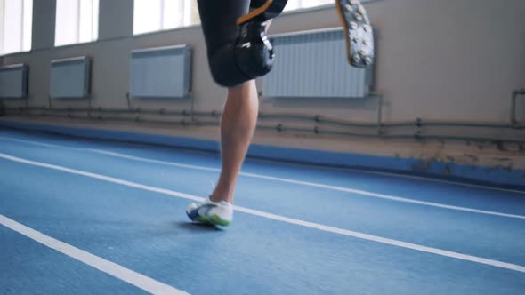 Sportsman with Bionic Leg Jogging on a Track