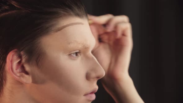 Drag Artist  Young Man Blending in the Contour on His Eyebrows and Forehead