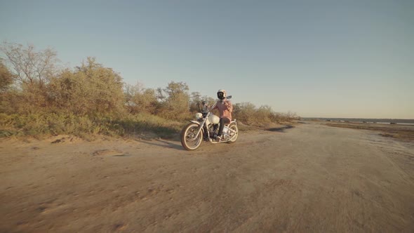 Motorcyclist Driving His Motorbike on the Dirt Road During Sunset Slow Motion