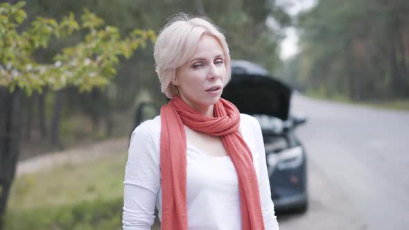 Tired Young Woman Turning To Camera and Wiping Forehead with Hand. Portrait of Exhausted Caucasian