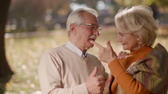 Healthy senior couple holding hands in the outdoor cafe on a sunny autumn day