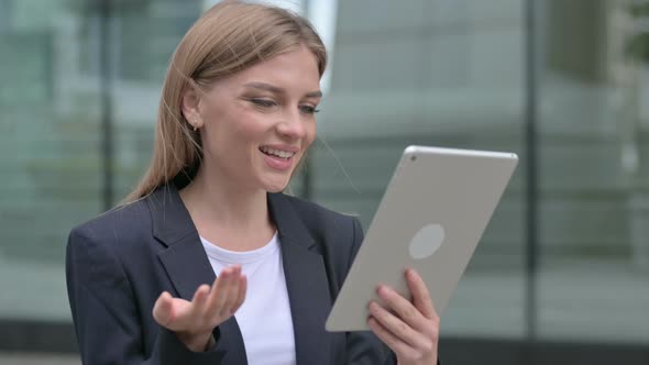 Young Businesswoman Talking on Video Call on Tablet While Walking on the Street