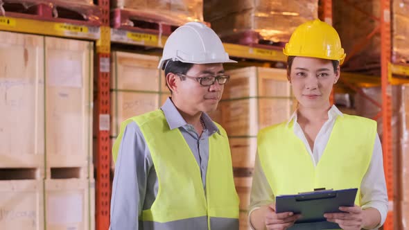 asian Male and Female Industrial Engineers in Hard Hats