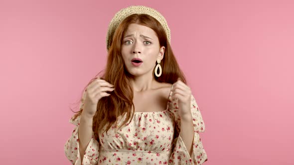 Portrait of Young Unpleasantly Surprised and Shocked Girl on Pink Studio Background. Woman Receiving