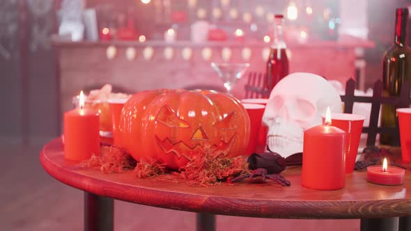 Jack-o-lantern Halloween Symbol on a Table with a Skull and Candles