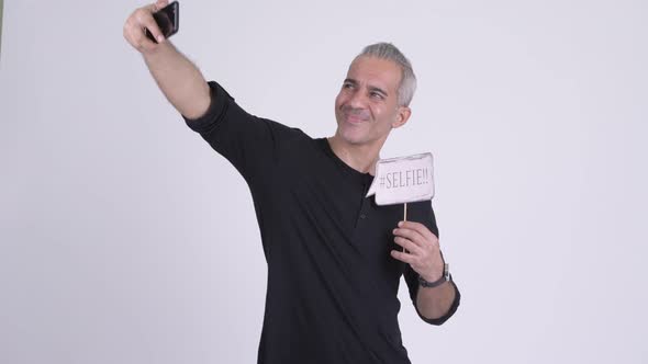 Happy Handsome Persian Man Taking Selfie with Paper Sign