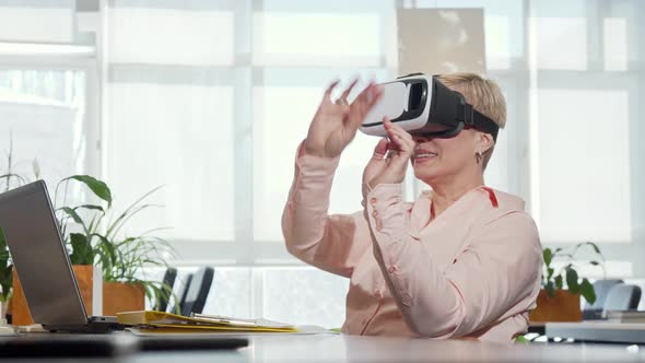 Mature Businesswoman Trying 3d Virtual Reality Glasses at Her Workplace