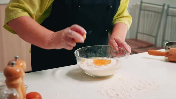 Close Up of Hands Woman Adding Eggs in Flour