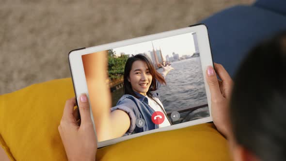 Young Asian woman using tablet video call talking with friends while living at home.