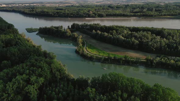 a small motorboat going slow on a small canal on the Danube