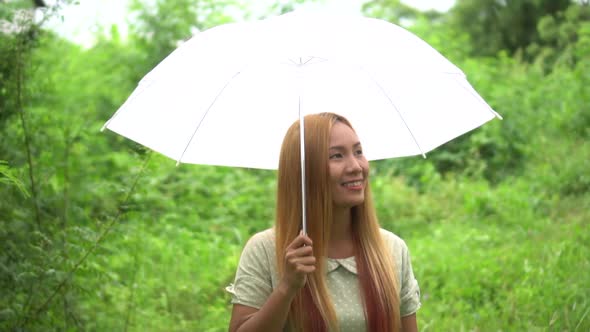 Woman walking hand holding white umbrella under rain