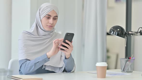 Young Arab Woman Using Smartphone in Office