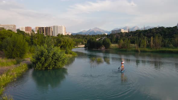 Man Ride on SUP Board in the Mountain Lake