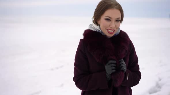 Portrait of a Young Beautiful Woman on a Background of Snow