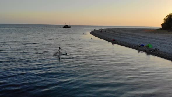 Woman Swims on the SUP Board and Returns to the Seashore