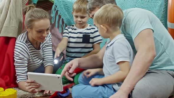 Joyous Parents and Kids Playing with Tablet alt