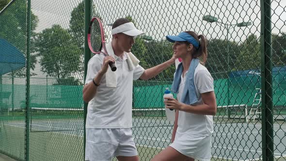 Couple Chatting after Playing Tennis at Outdoor Court