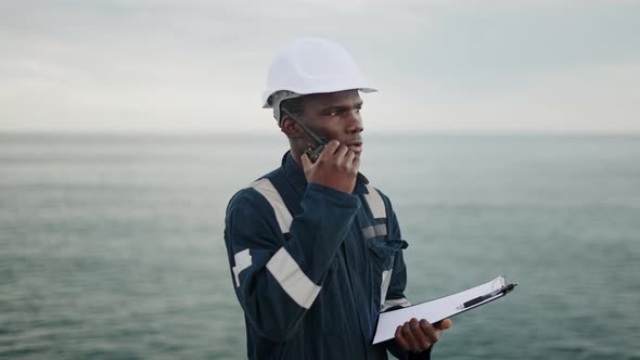 Serious Maritime Worker Speaking on Walkie Talkie