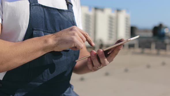 Closeup Focus on Hands of an Engineer Who is Holding a Tablet and Working on It