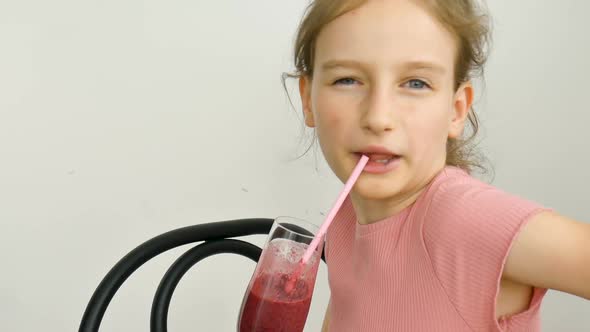 Sweet Little Girl Drinks Raspberry Smoothie and Smiles