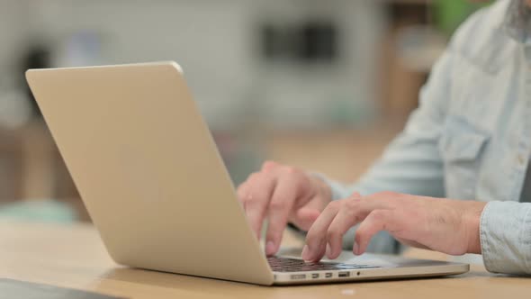 Close Up of Creative Young Man Typing on Laptop