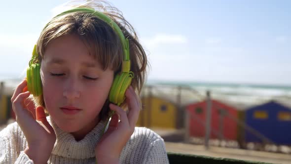 Girl listening music on headphones at beach 