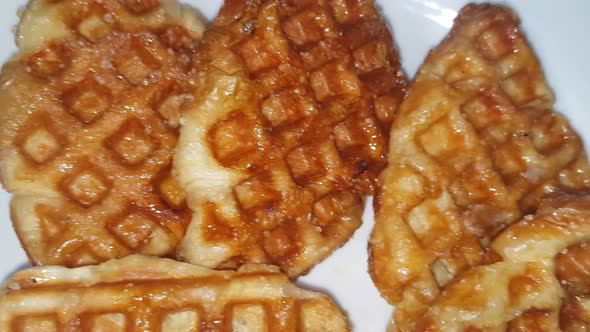 Stack of Croissant waffle or croffle served in white plate and wooden background