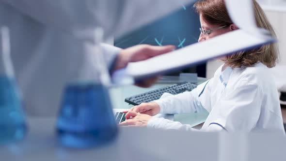 Handheld Shot of Scientist Woman Typing on Laptop alt