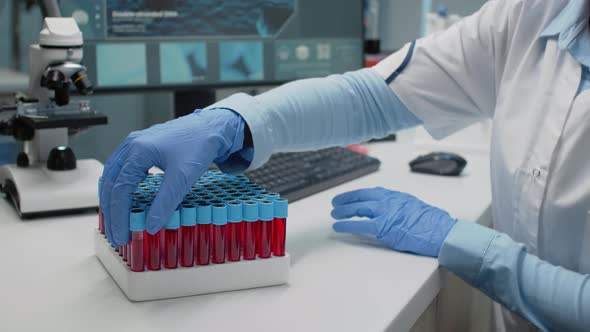 Doctor in Science Laboratory Analyzing Tray of Vacutainers