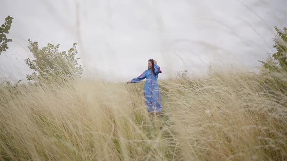 Beautiful Carefree Caucasian Girl Wearing Long Summer Fashion Dress Walking on the Field